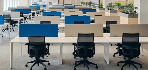 Modern open-plan office space featuring clean workstations, ergonomic chairs, and sanitized carpets provided by professional office cleaning services in Detroit, MI.